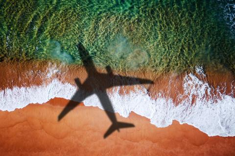 An airplane flying over land and sea.